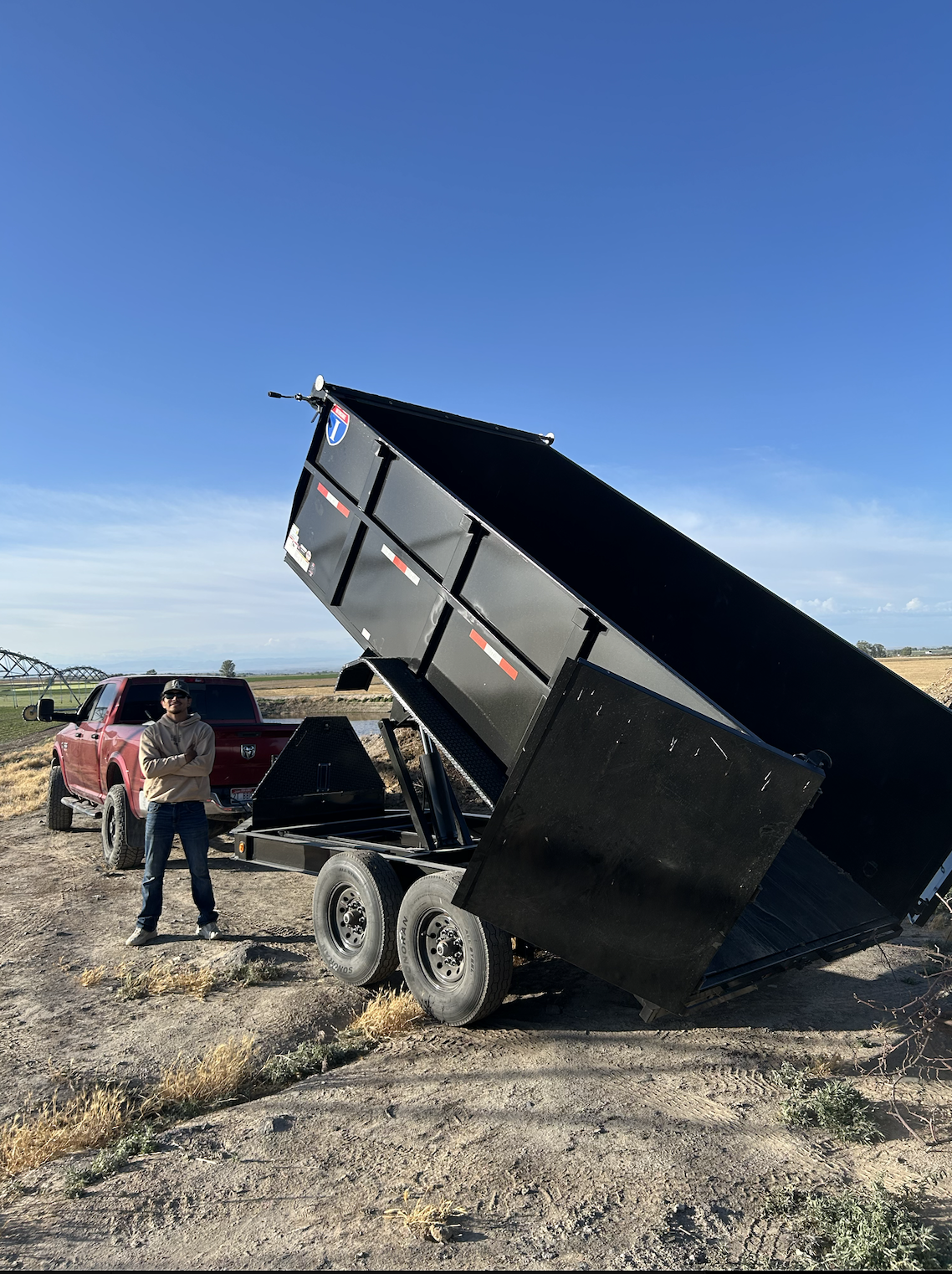 ProHaul team member with raised dump trailer at job site